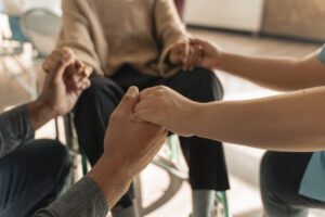 três idosos de mãos dadas formando um círculo